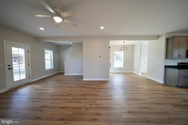 unfurnished living room featuring hardwood / wood-style flooring and ceiling fan