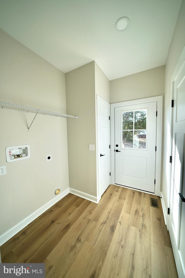 laundry area with electric dryer hookup, light hardwood / wood-style flooring, and washer hookup