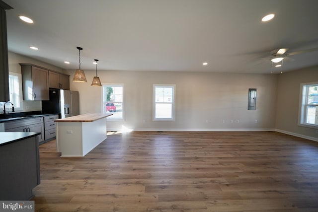 kitchen with dark hardwood / wood-style floors, plenty of natural light, wooden counters, and stainless steel refrigerator with ice dispenser