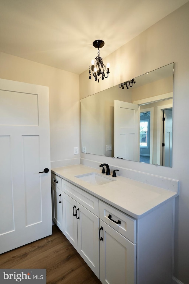 bathroom with hardwood / wood-style flooring, vanity, and an inviting chandelier