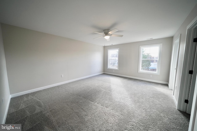 carpeted spare room featuring ceiling fan