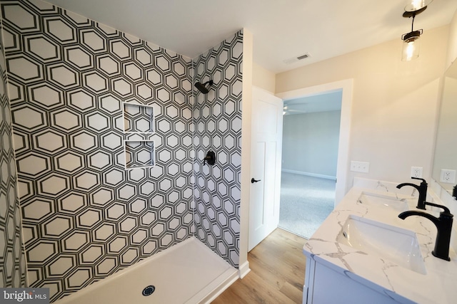 bathroom featuring wood-type flooring, vanity, and walk in shower