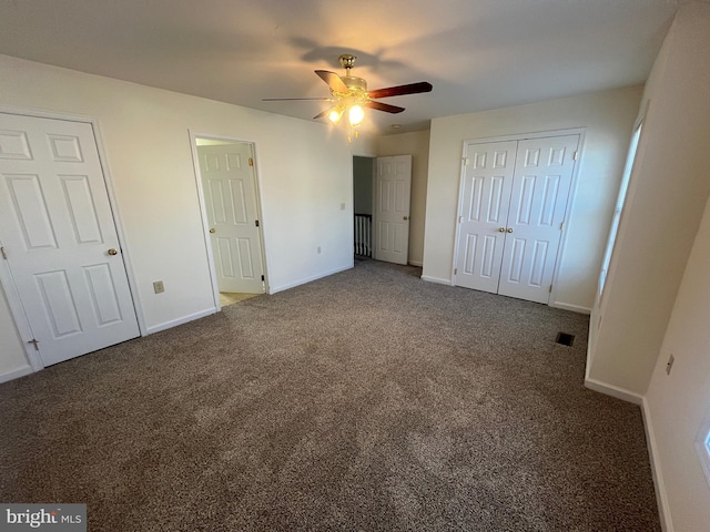 unfurnished bedroom with dark colored carpet and ceiling fan