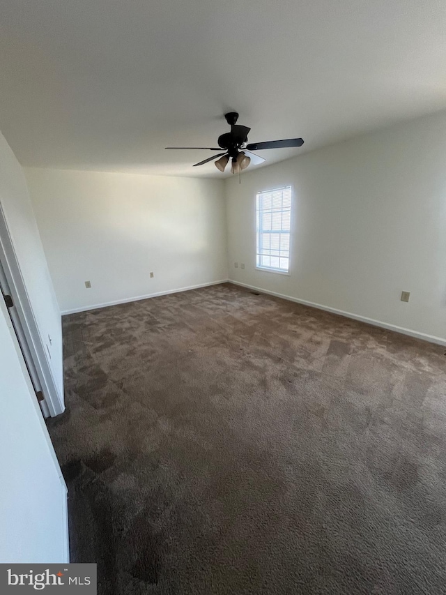 carpeted spare room featuring ceiling fan