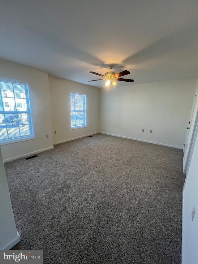 unfurnished room featuring dark carpet and ceiling fan