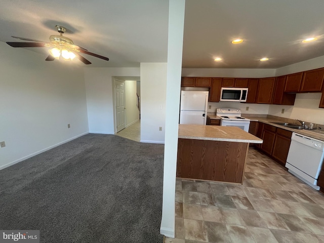 kitchen with ceiling fan, sink, light colored carpet, white appliances, and a kitchen island