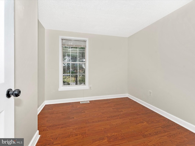 spare room with hardwood / wood-style floors and a textured ceiling