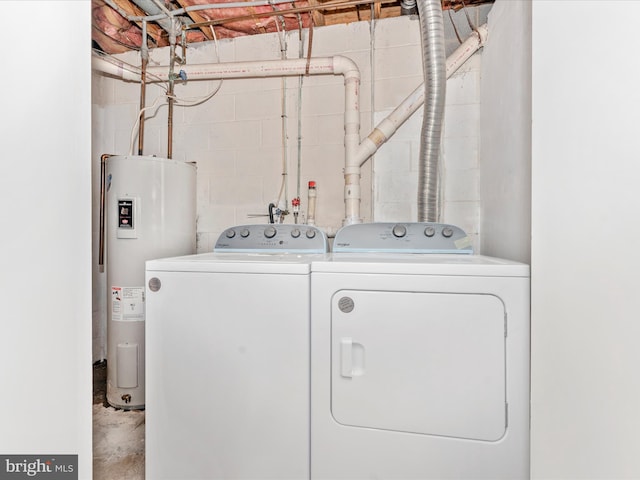 washroom with washing machine and dryer and water heater