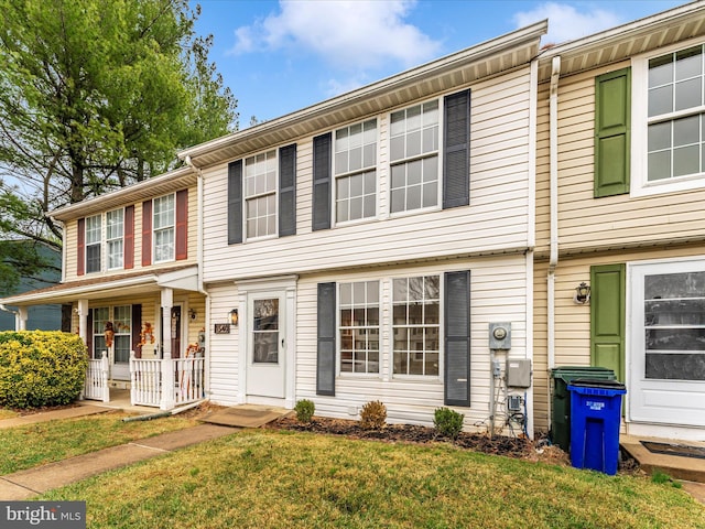 multi unit property featuring a front lawn and covered porch