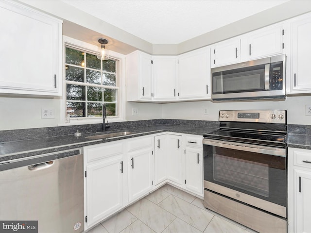 kitchen featuring stainless steel appliances, white cabinetry, and sink