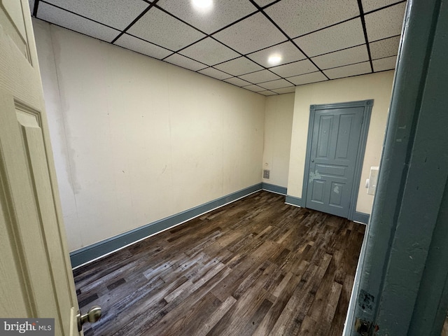 unfurnished room with a paneled ceiling and dark wood-type flooring