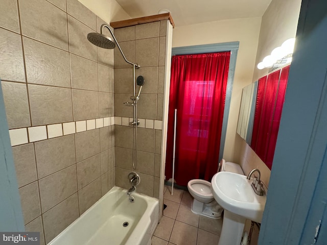 full bathroom with tile patterned flooring, tiled shower / bath combo, toilet, and sink