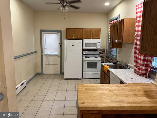 kitchen featuring tasteful backsplash, white appliances, ceiling fan, baseboard heating, and sink