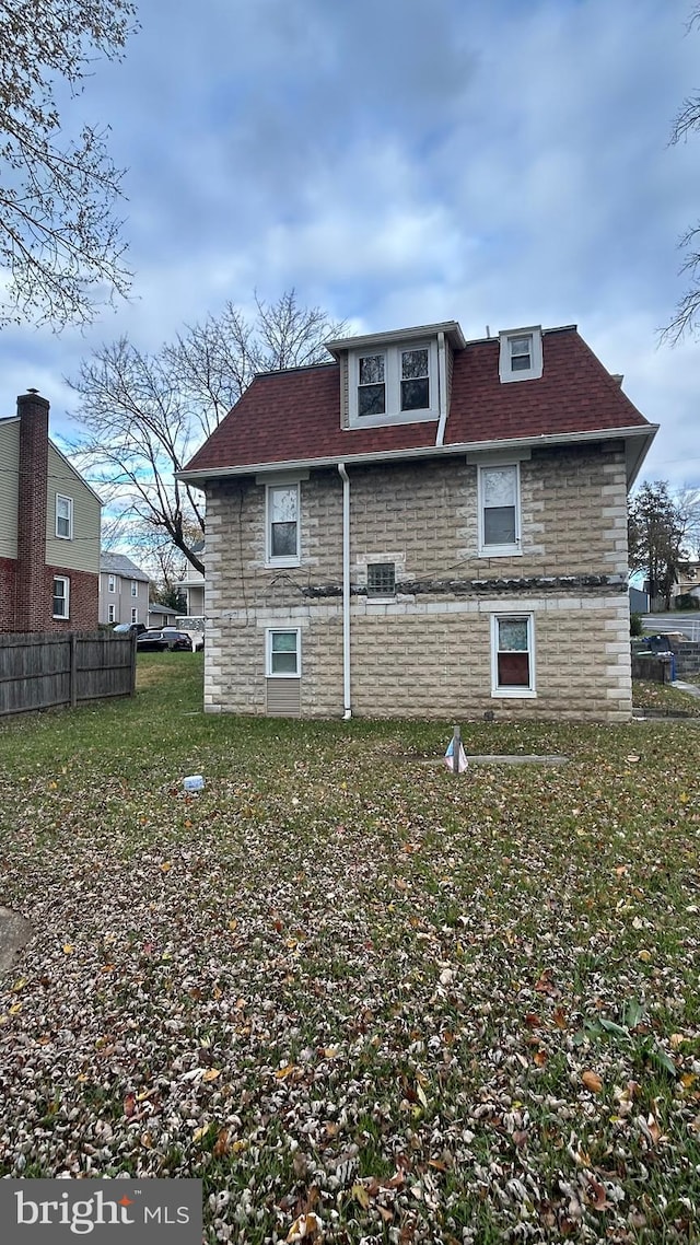 rear view of property with a lawn