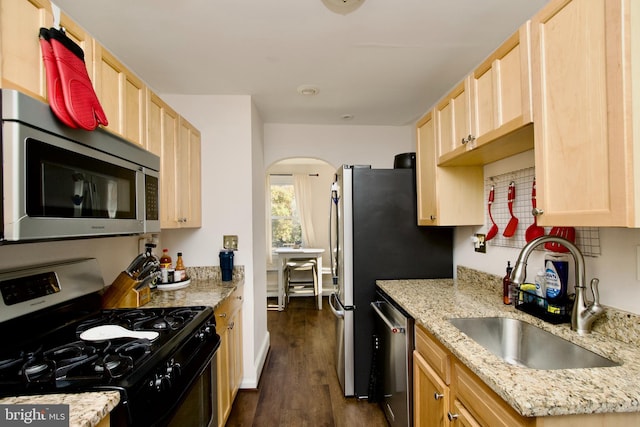 kitchen featuring dark wood-type flooring, sink, light brown cabinetry, light stone counters, and stainless steel appliances