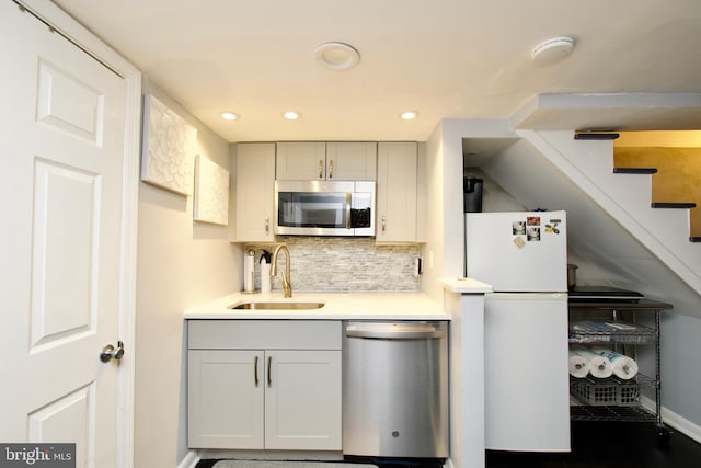 kitchen featuring backsplash, gray cabinetry, sink, and appliances with stainless steel finishes