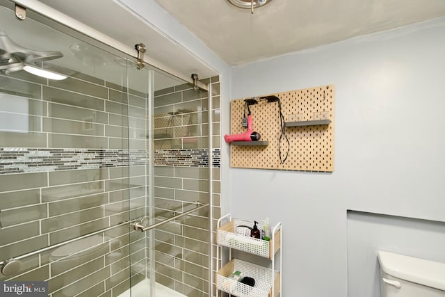 bathroom with a tile shower and toilet