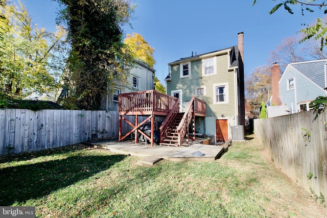 back of property with a lawn and a deck