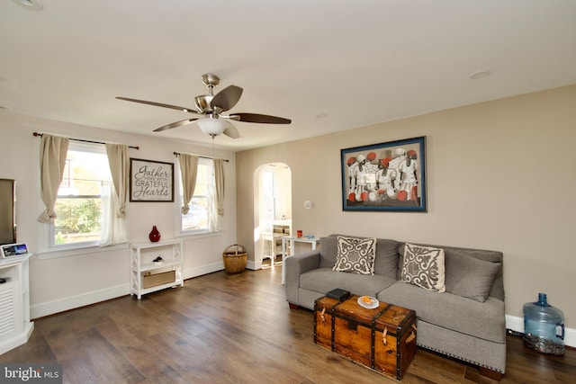 living room featuring ceiling fan and dark wood-type flooring