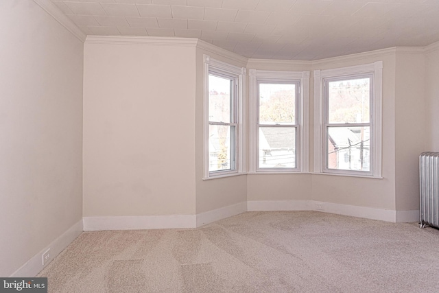 carpeted empty room featuring ornamental molding and radiator