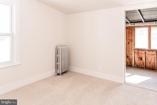 empty room with radiator heating unit and carpet floors