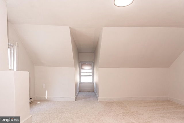 bonus room with baseboard heating, light colored carpet, and lofted ceiling