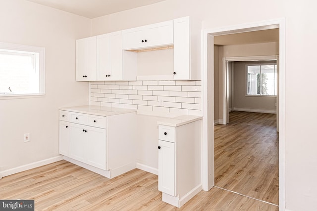 kitchen featuring light hardwood / wood-style flooring, white cabinets, and a healthy amount of sunlight