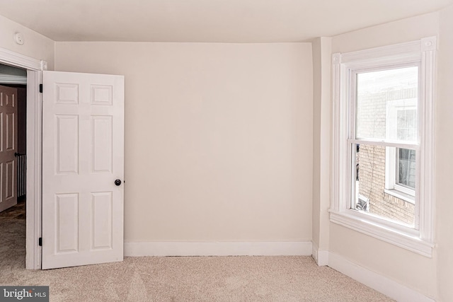 unfurnished room featuring light colored carpet and a healthy amount of sunlight