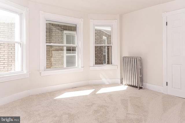 empty room featuring carpet flooring and radiator