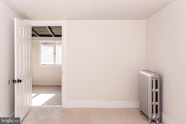 carpeted empty room featuring radiator