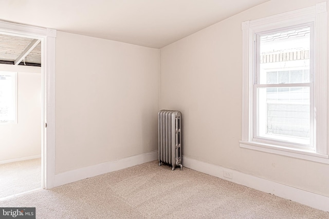 interior space with radiator heating unit, light colored carpet, and lofted ceiling