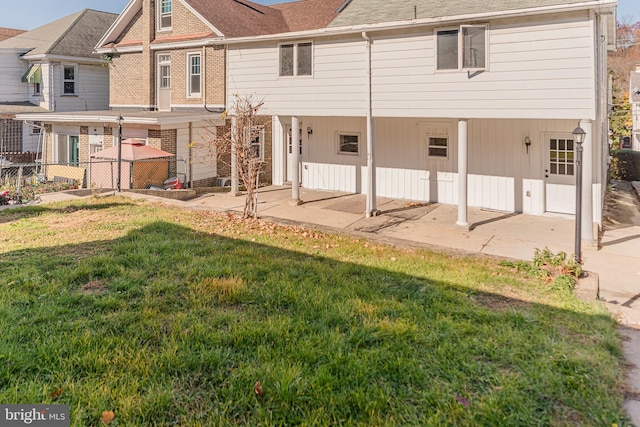 rear view of house with a yard and a patio