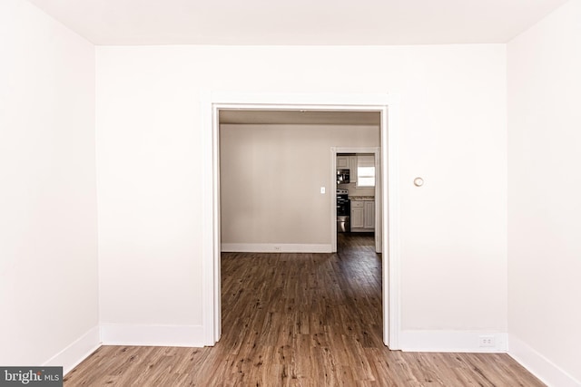 hallway with hardwood / wood-style flooring