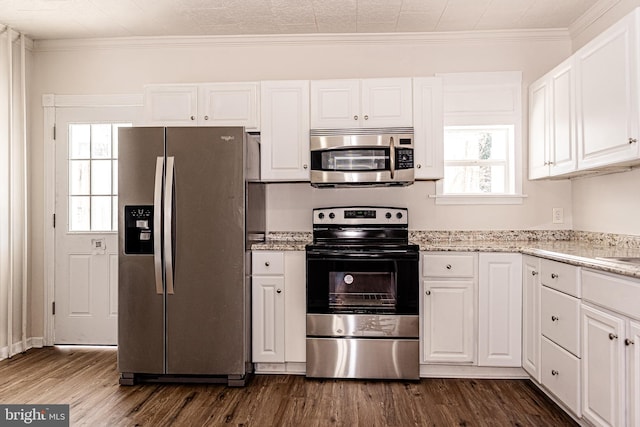 kitchen featuring white cabinetry, dark wood-type flooring, stainless steel appliances, and ornamental molding