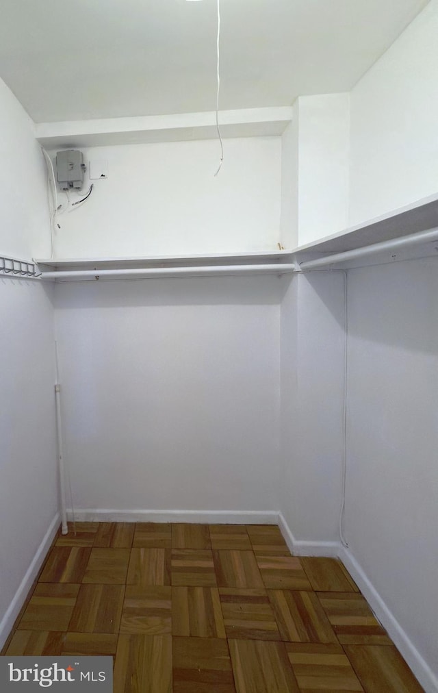 spacious closet featuring dark parquet floors