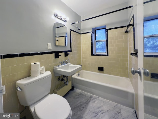 full bathroom with plenty of natural light, toilet, tile walls, and tiled shower / bath combo