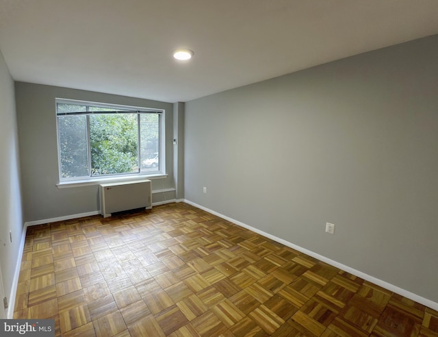 spare room featuring light parquet floors and radiator