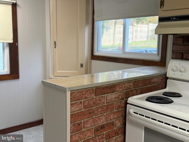 kitchen featuring electric range and exhaust hood