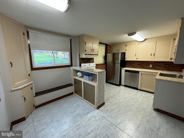 kitchen featuring tasteful backsplash, cream cabinets, sink, and appliances with stainless steel finishes