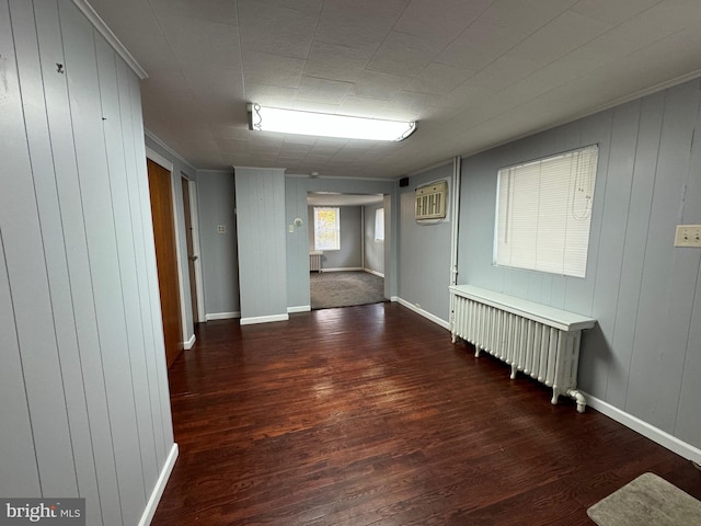 hall with dark hardwood / wood-style floors, radiator, and wooden walls