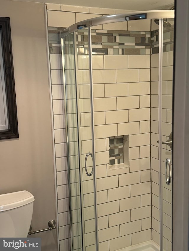 bathroom featuring an enclosed shower and toilet