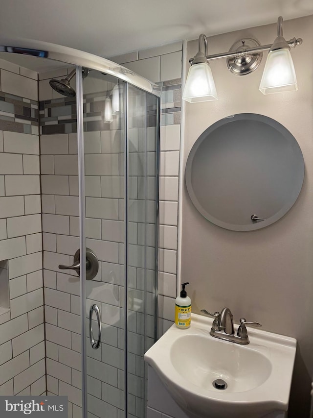 bathroom with sink and a shower with shower door