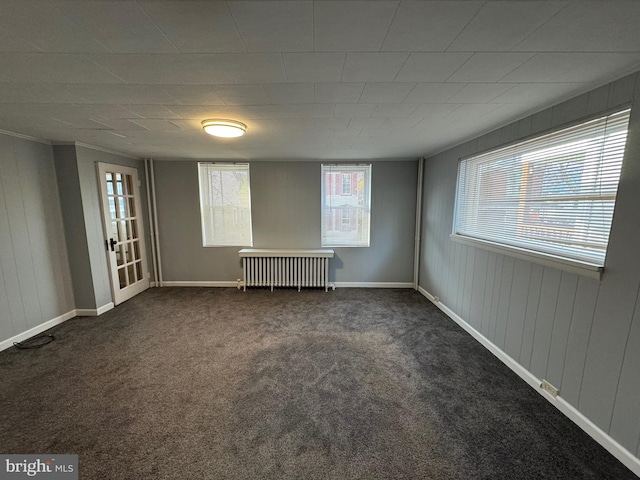 carpeted spare room featuring radiator heating unit