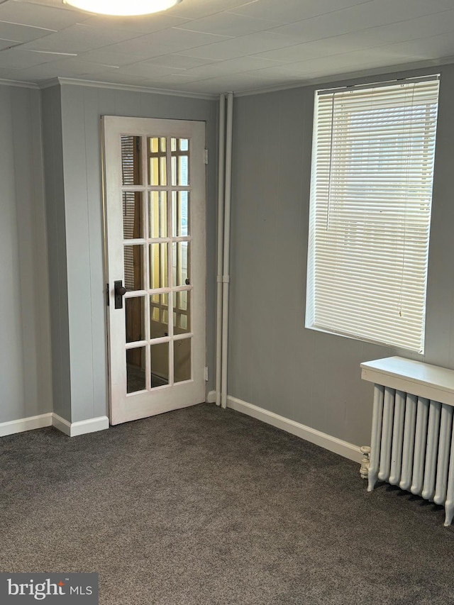 carpeted spare room with radiator and ornamental molding