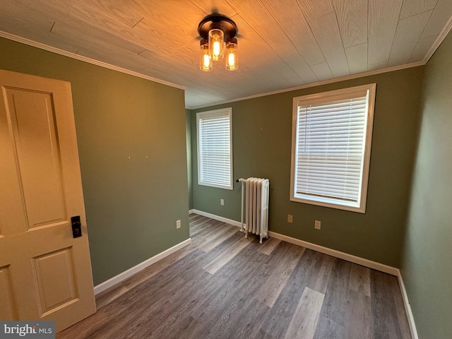 unfurnished room with hardwood / wood-style floors, wood ceiling, crown molding, and radiator