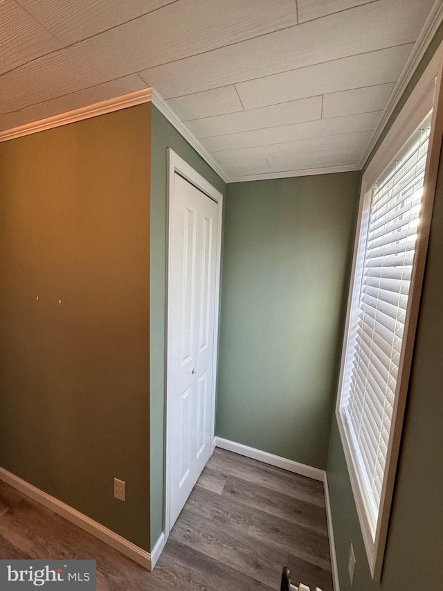 unfurnished bedroom featuring hardwood / wood-style flooring, ornamental molding, and a closet