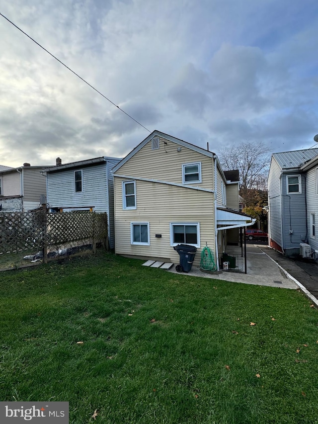 back of house with a yard and a patio