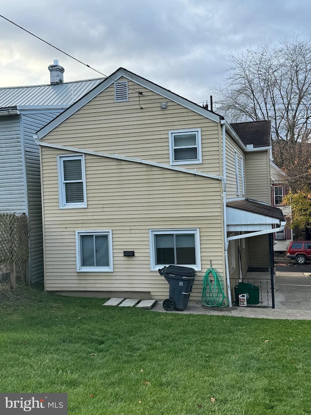 rear view of property featuring a lawn