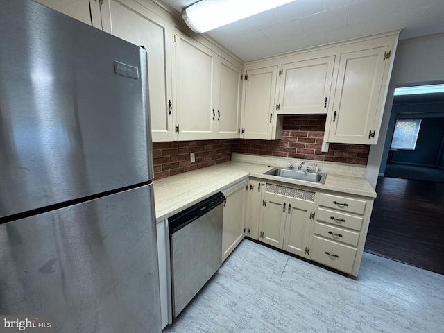 kitchen featuring white cabinets, appliances with stainless steel finishes, tasteful backsplash, and sink