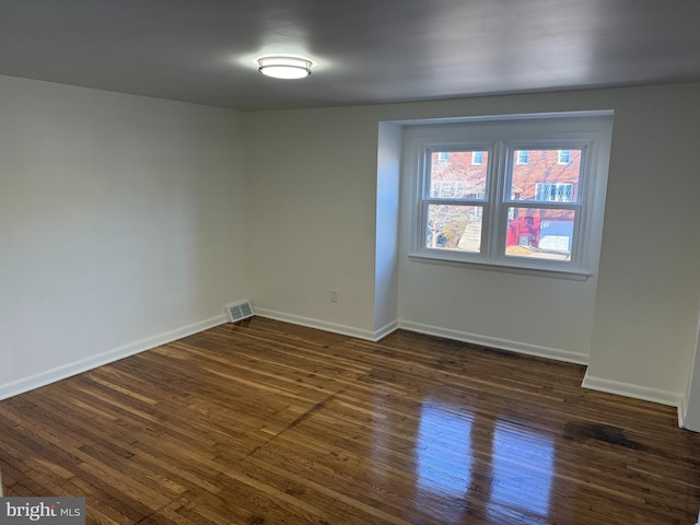 unfurnished room with dark hardwood / wood-style flooring